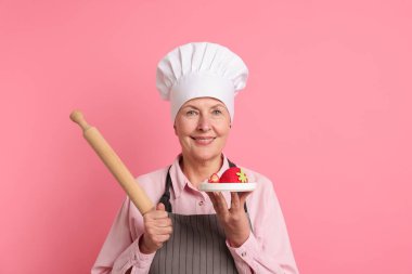 Profesyonel şekerci, tatlı ve pembe arka planda merdane.