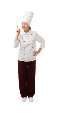 Profesyonel pasta şefi beyaz arka planda bir şeye işaret ediyor.