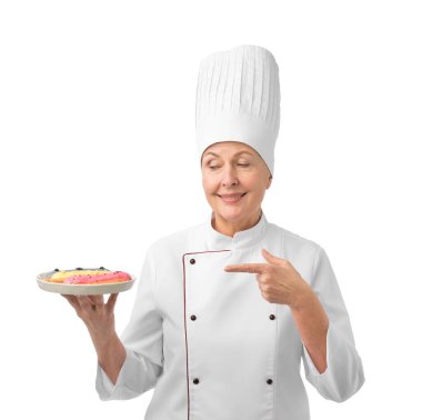 Profesyonel pasta şefi beyaz arka plandaki eklerlere işaret ediyor.