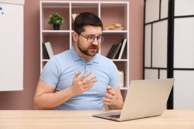 İçerideki masada dizüstü bilgisayarla çevrimiçi hoparlör çalışıyor.