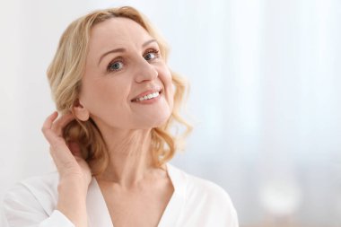 Bulanık arka planda gülümseyen orta yaşlı kadın portresi. Metin için boşluk