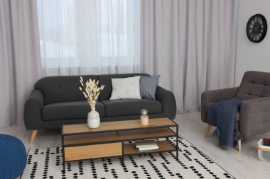 Rahat kanepe ve güzel pencere perdeleri olan şık bir oda.
