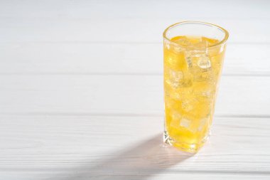 Beyaz ahşap masada buzlu tatlı soda, yazı için yer var.