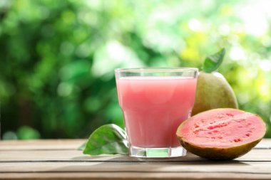 Guava suyunu tazeliyorum ve ahşap masada taze meyveler, yakın plan. Metin için boşluk