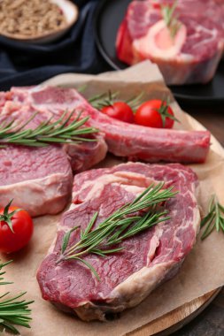 Çiğ et, biberiye ve domates parçaları masada, yakın plan.