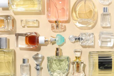 Bej arka planda çeşitli parfüm şişeleri, düzlük