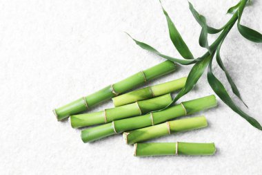 Bambu saplarını ve yapraklarını beyaz desenli masa üzerinde düz bir şekilde kes.