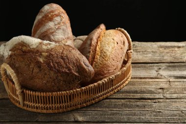 Tahta masadaki sepetin içinde farklı somunlar, yakın çekim.