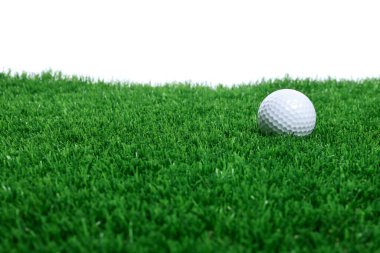 Beyaz arka plana karşı yeşil çimlerde golf topu