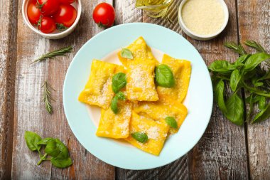 Tahta masada servis edilen peynirli ve fesleğenli lezzetli ravioli.