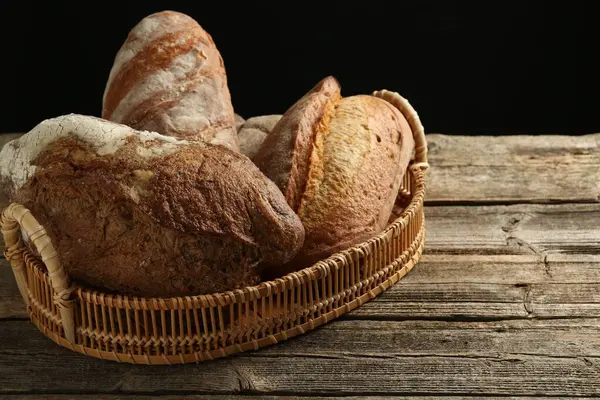 Tahta masadaki sepetin içinde farklı somunlar, yakın çekim.