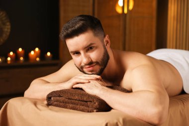 Güzellik salonunda masaj masasında yatan yakışıklı adam.