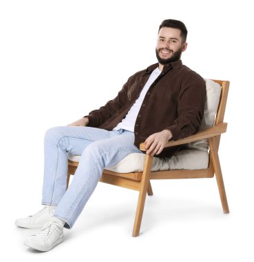 Gülen adam beyaz arka planda sandalyede dinleniyor.