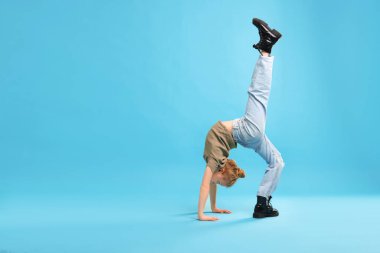 Açık mavi arka planda dans eden şık elbiseli kız, metin için yer var.