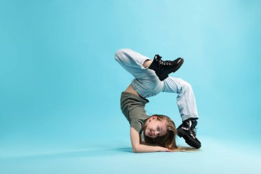 Açık mavi arka planda dans eden şık elbiseli kız, metin için yer var.