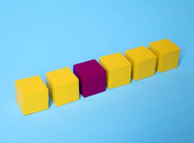 Farklı, eşsiz, özel. Açık mavi arkaplanda sarı olanlar arasında mor küp