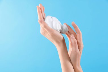 Açık mavi arka planda kozmetik köpüklü kadın, metin için yeri olan yakın plan