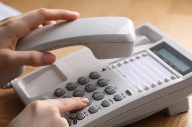 Ahşap masada telefonla arayan kadın, yakın plan.