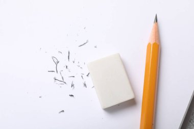 Eraser, pencil and scraps on sheet of paper, flat lay