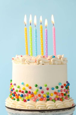 Rengarenk serpiştirilmiş nefis bento keki ve arka planda yanan mumlar, yakın plan.