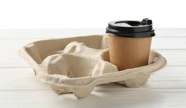 Kağıt kahve fincanı beyaz ahşap masanın üzerinde karton tutacakta, yakın plan.