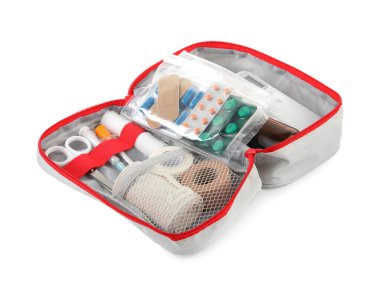 İlk yardım çantası. Çantadaki farklı tıbbi malzemeler beyaza izole edilmiş.