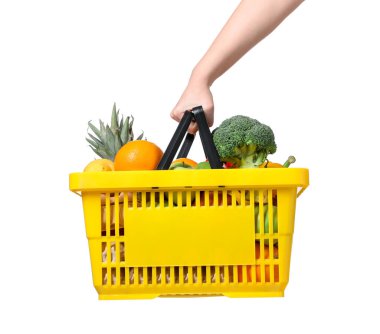 Beyaz arka planda farklı gıda ürünleri olan alışveriş sepeti tutan kadın, yakın plan.