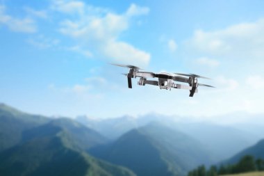 Dağlarda uçan kameralı bir dron. Gözetleme için insansız hava aracı