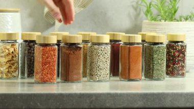 Baharat seçen ve biberli kavanoz alan bir kadın.