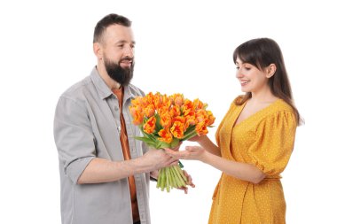 Adam beyaz arka planda sevgili karısına güzel laleler sunuyor.