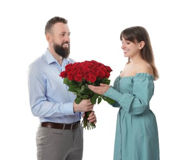 Adam beyaz arka planda sevgilisine kırmızı gül buketi sunuyor.