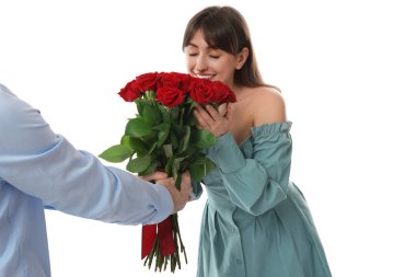 Adam beyaz arka planda sevgilisine kırmızı gül buketi sunuyor.