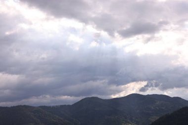 Bulutlu gökyüzünün altındaki güzel dağların resimli görüntüsü