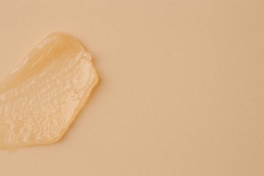 Bej arka planda nemlendirici dudak kremi, üst manzara. Metin için boşluk