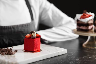 Mutfaktaki siyah mermer masada lezzetli bir tatlıyla şekerleme, yakın plan.