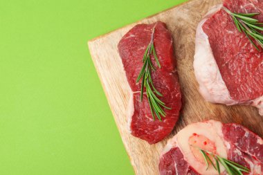 Yeşil masada çiğ sığır eti ve biberiye parçaları. Metin için boşluk