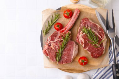 Çiğ sığır eti, biberiye ve domates parçaları beyaz fayanslı masa, düz yatak. Metin için boşluk