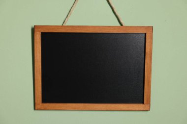 Açık yeşil duvarda boş bir karatahta