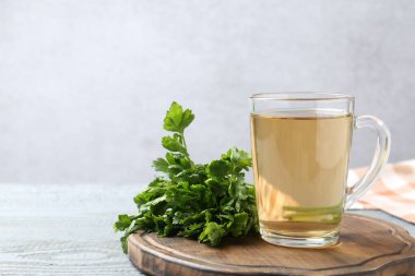 Sağlıklı maydanoz çayı gri ahşap masada, yazı için yer var. Detoks içeceği
