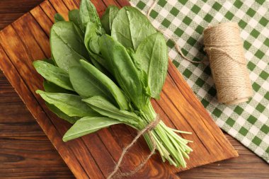 Taze yeşil kuş yaprakları ve ahşap masa üzerinde sicim, düz yatıyordu.