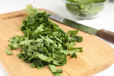 Beyaz ahşap masada taze at ve bıçak kes, yakın plan.