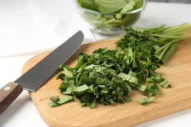 Beyaz ahşap masada taze at ve bıçak kes, yakın plan.