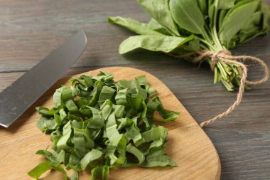 Tahta masada taze kuş yaprakları ve bıçak kes, yakın plan.