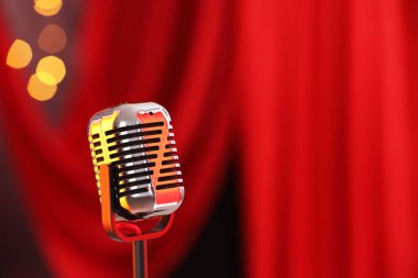 Kırmızı perdeye karşı bir klasik mikrofon, mesaj için yer. Bokeh etkisi