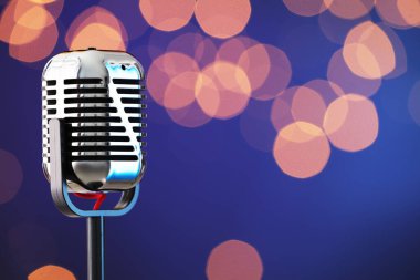 Koyu mavi arka plana karşı klasik bir mikrofon, mesaj için boşluk. Bokeh etkisi