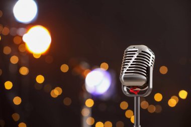 Karanlık arka plana karşı bir klasik mikrofon, mesaj için boşluk. Bokeh etkisi