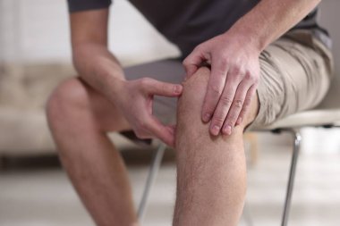 Evinde diz ağrısı çeken bir adam, yakın plan.