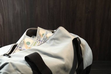 Masanın üzerinde dolar banknotları olan çanta, yakın plan.