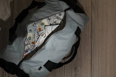 Tahta arka planda bir çanta dolusu banknot.