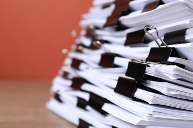 Portakal rengi arka planda kağıtlı cilt klipsleri, yakın plan. Metin için boşluk